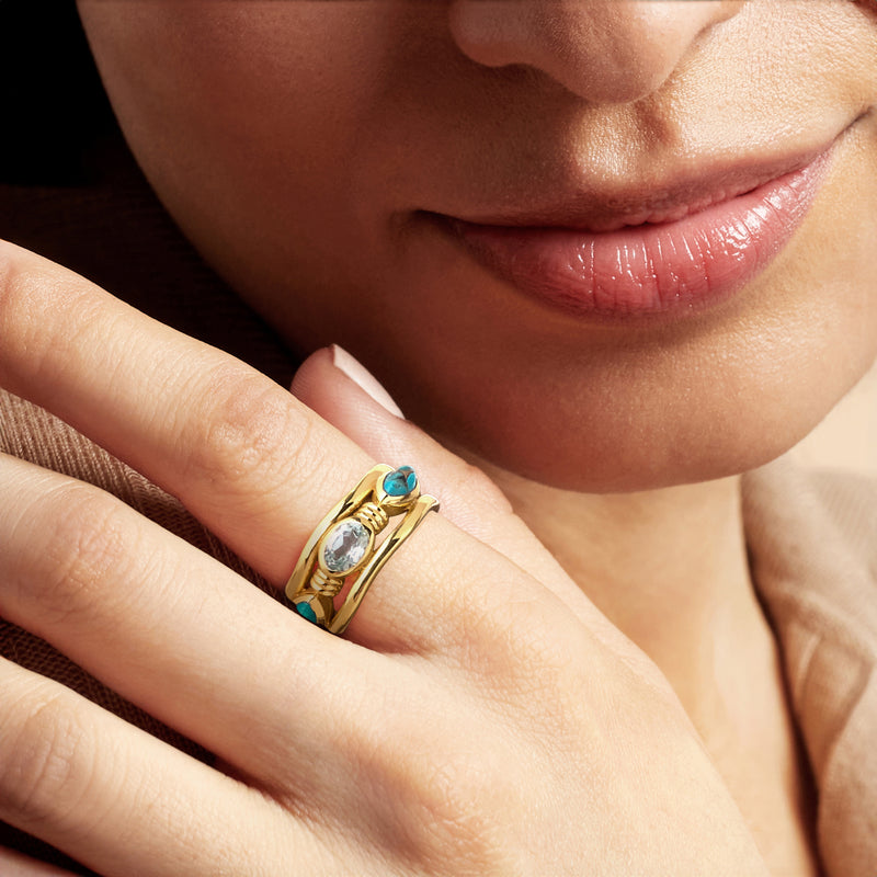 18kt gold over sterling ring on hand, oval sky-blue topaz with turquoise stones