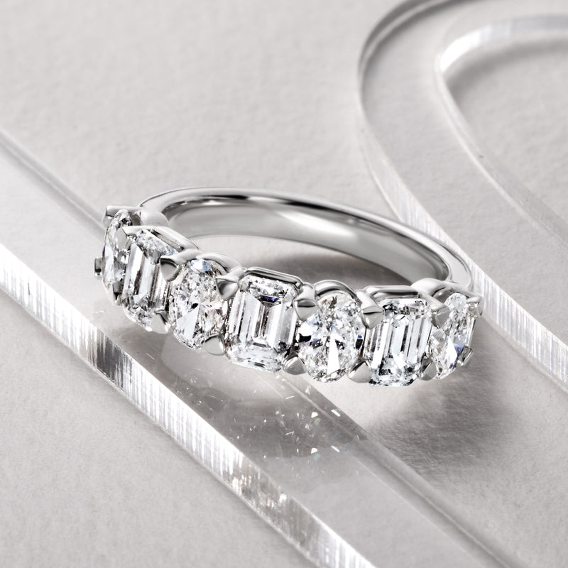 14kt white gold diamond ring with oval center and emerald-cut stones, angled view
