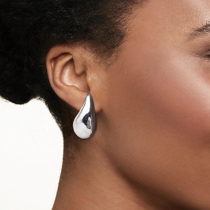 Sterling silver teardrop drop earring on ear, glossy teardrop drop
