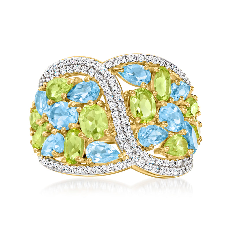 Crisscross gold ring with blue and green gemstones and diamond halo accents