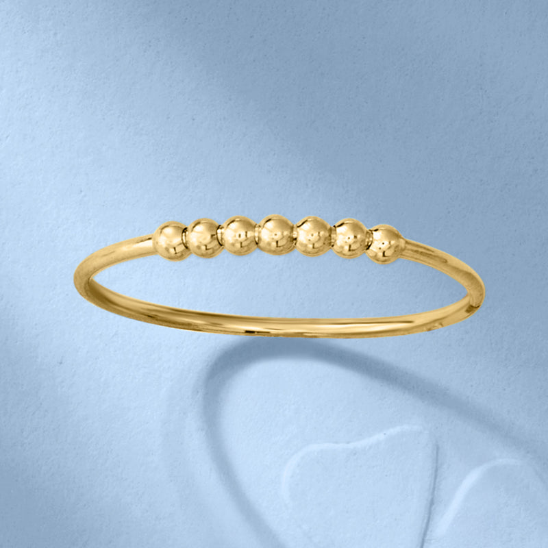 Gold bead station ring showing top row of small round beads on slender band