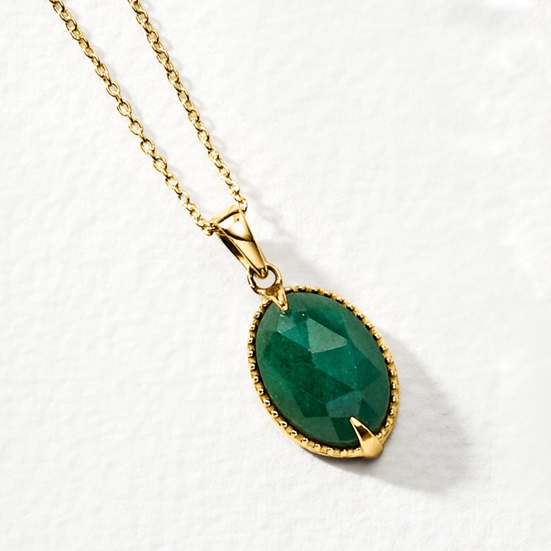 Oval green emerald-cut pendant with gold bezel and link chain, angled view