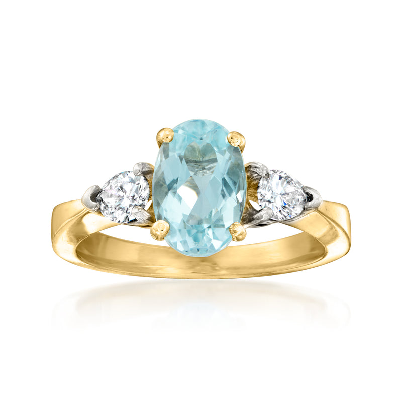 18kt yellow gold ring with oval aquamarine center and round diamond side stones
