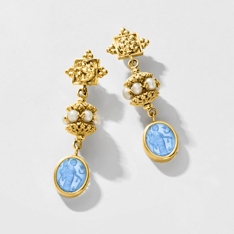 Gold drop earrings with dangling blue oval glass medallion, faux pearls, and textured beads