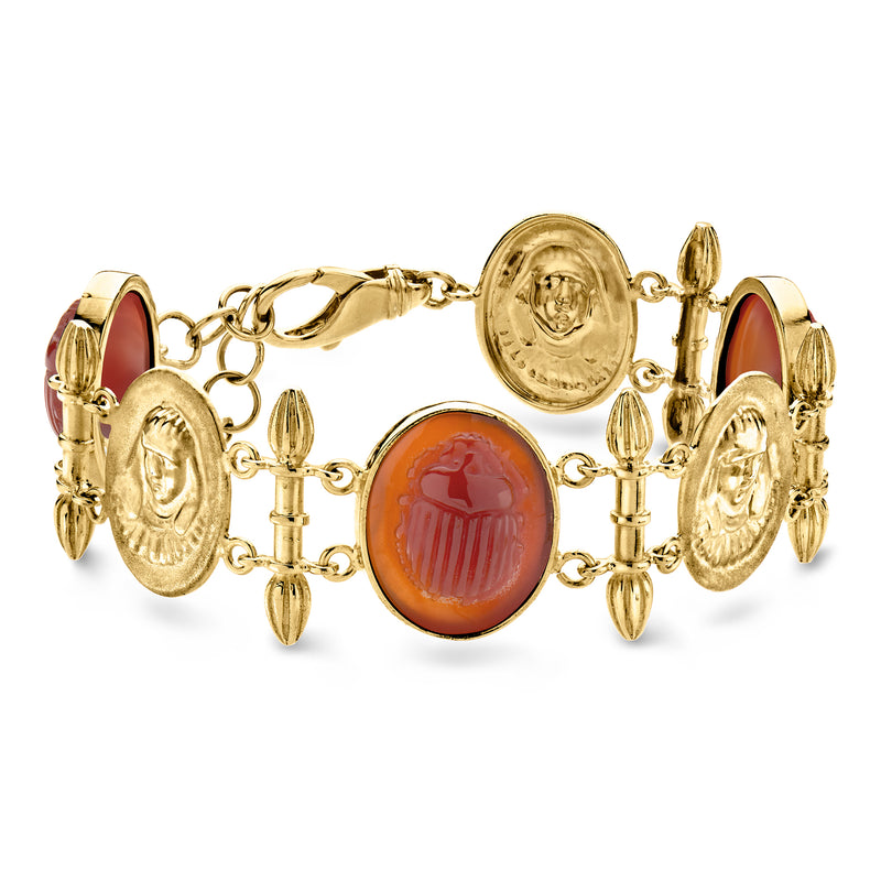 Gold-tone scarab bracelet with red oval gemstone links and ornate oval medallions