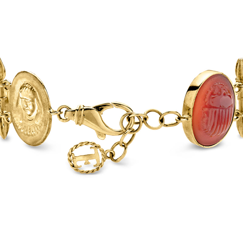 Gold-tone bracelet with red scarab cabochon centerpiece and circular dangling charm