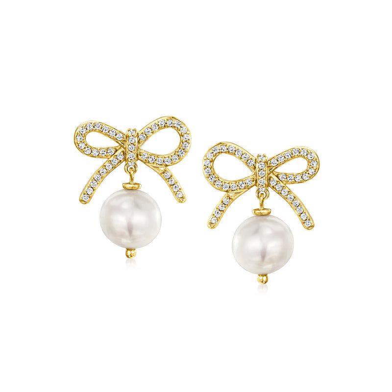 Bow drop earrings with gold-tone setting, clear stones, and white pearl dangles