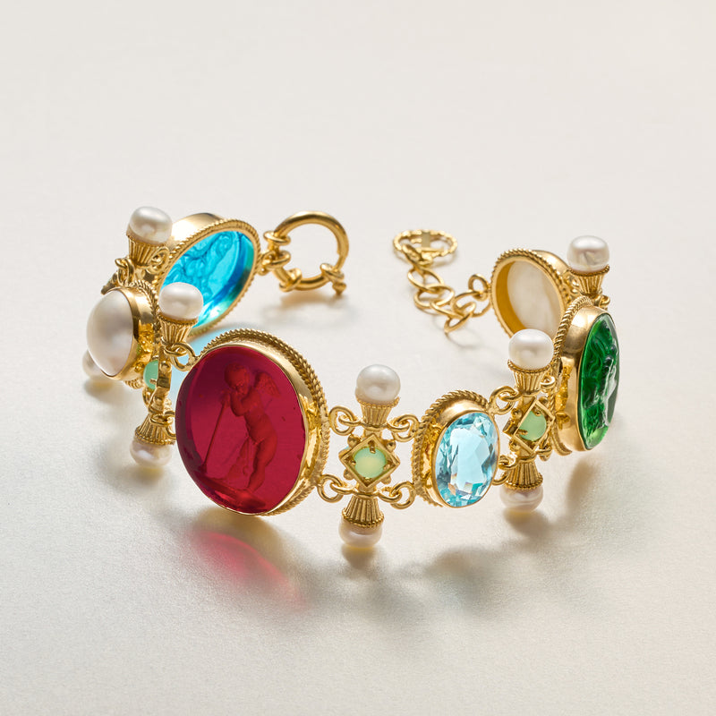Gold-tone bracelet close-up with blue, red, green glass cabochons and small white pearls