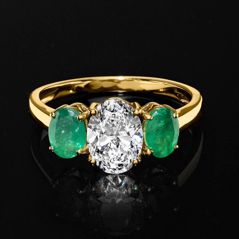 14kt yellow gold ring with oval lab-grown diamond center and two green emerald side stones
