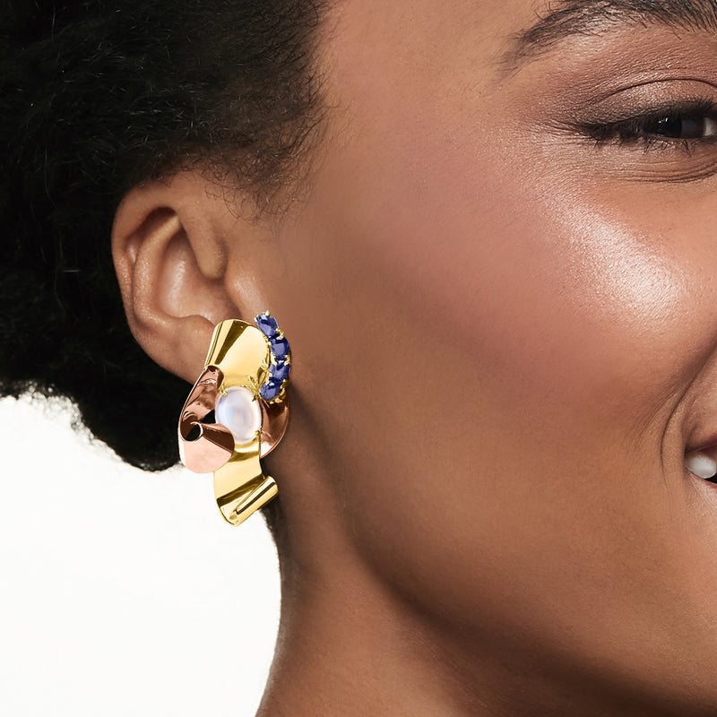 Two-tone gold earrings with oval moonstone and blue sapphire cluster, worn on ear