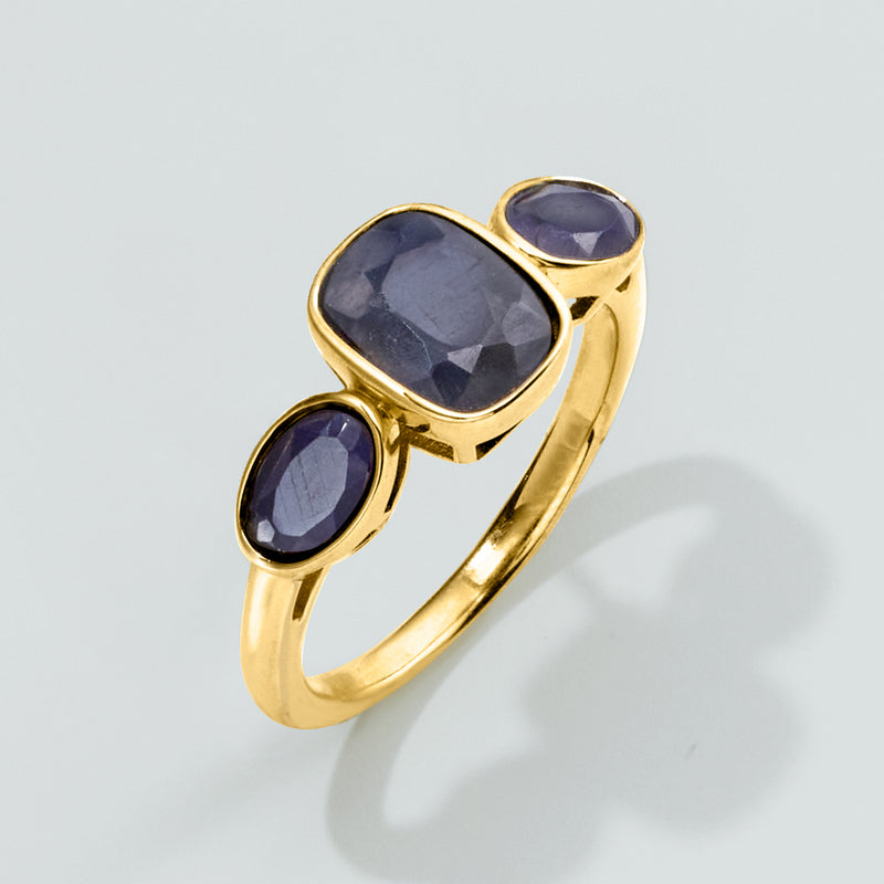 Gold three-stone sapphire ring with large cushion-cut center and two oval blue stones