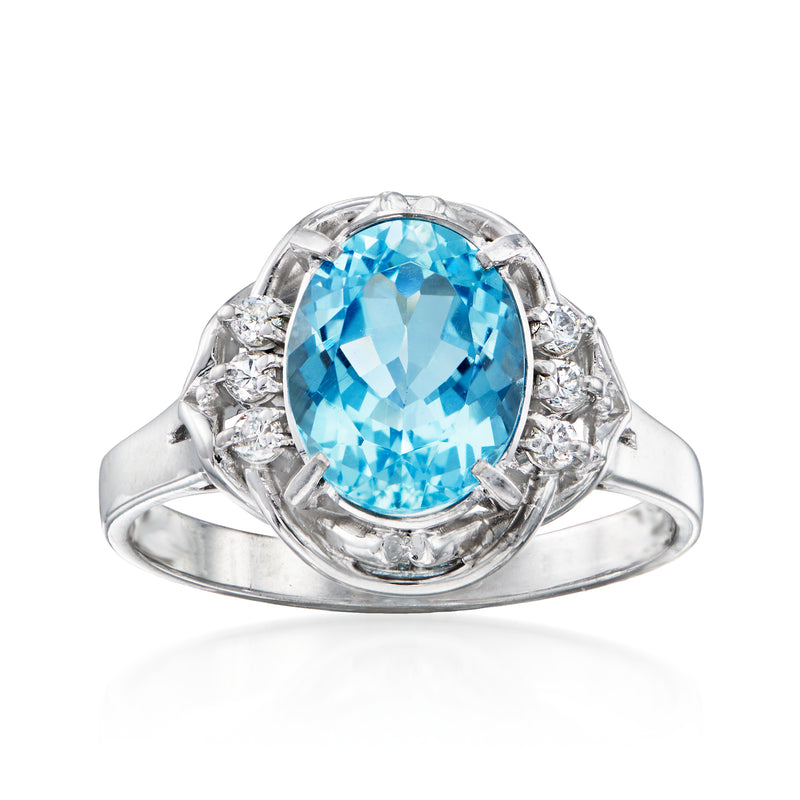 Platinum aquamarine and diamond vintage ring with oval blue gemstone and side halo
