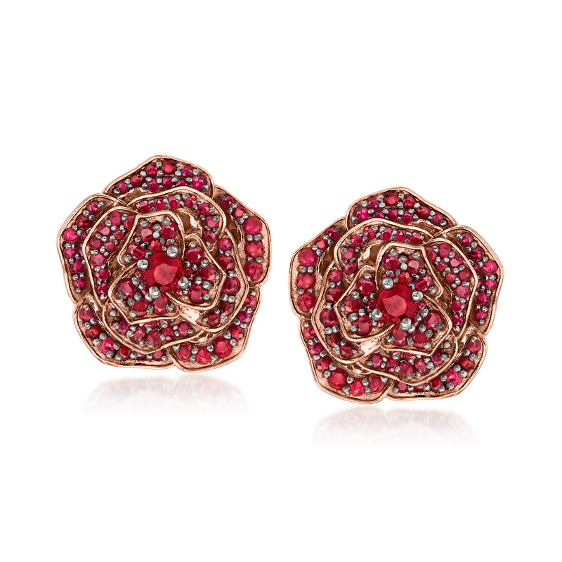Flower-shaped ruby-stone stud earrings in rose gold tone with red gemstone accents