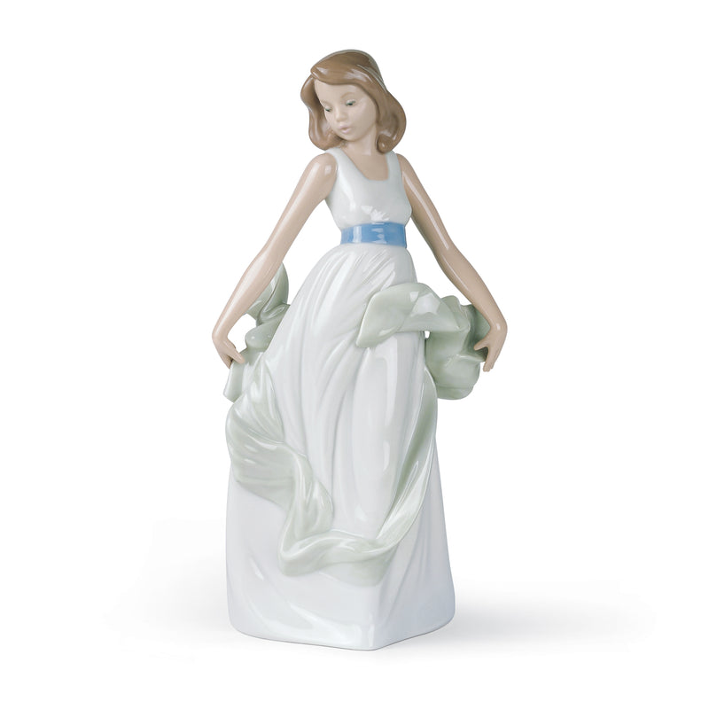 Porcelain figurine of a girl in a white dress with blue sash, holding green fabric