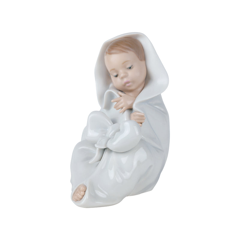Porcelain baby figurine in hooded blanket, kneeling and holding a stuffed bear