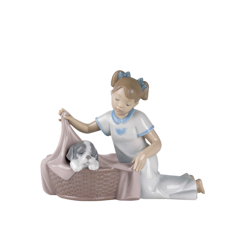 Porcelain figurine of a child seated in a wicker basket with a resting puppy
