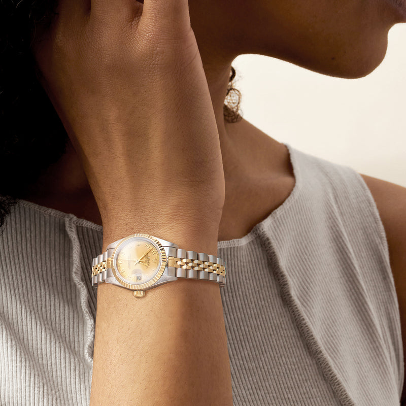 Rolex Datejust women's watch on wrist, yellow-gold bezel and stainless link bracelet