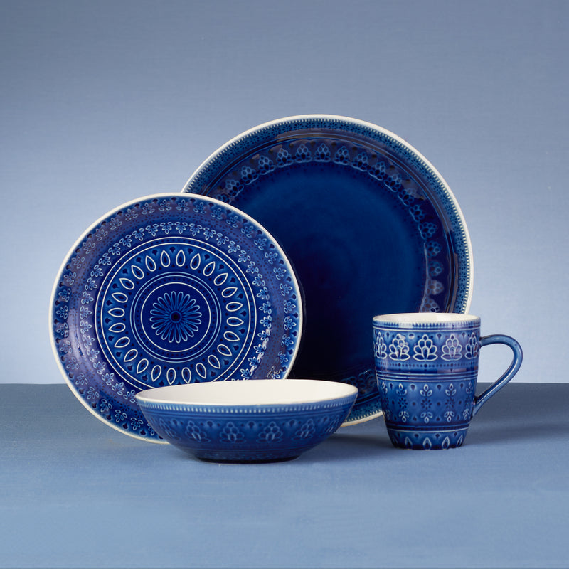 Cobalt blue stoneware dinnerware set with patterned plates, bowl, and mug