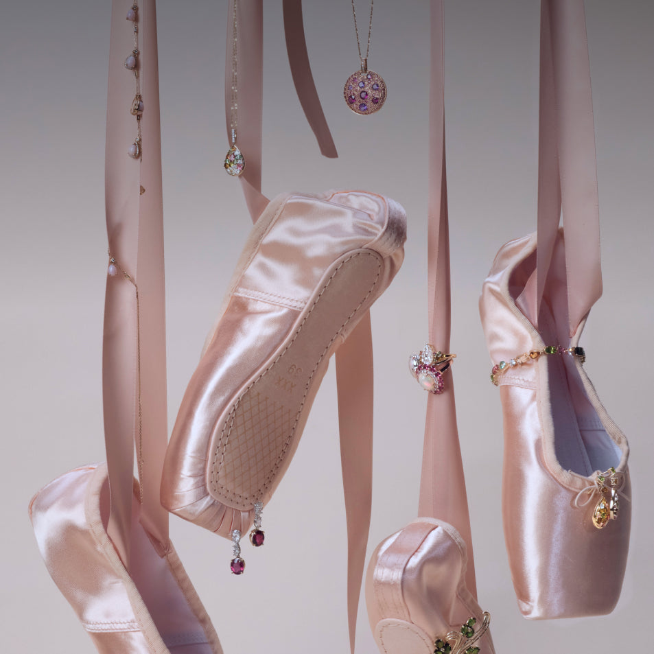 Pink ballerina shoes hanging with assorted jewelry mixed in