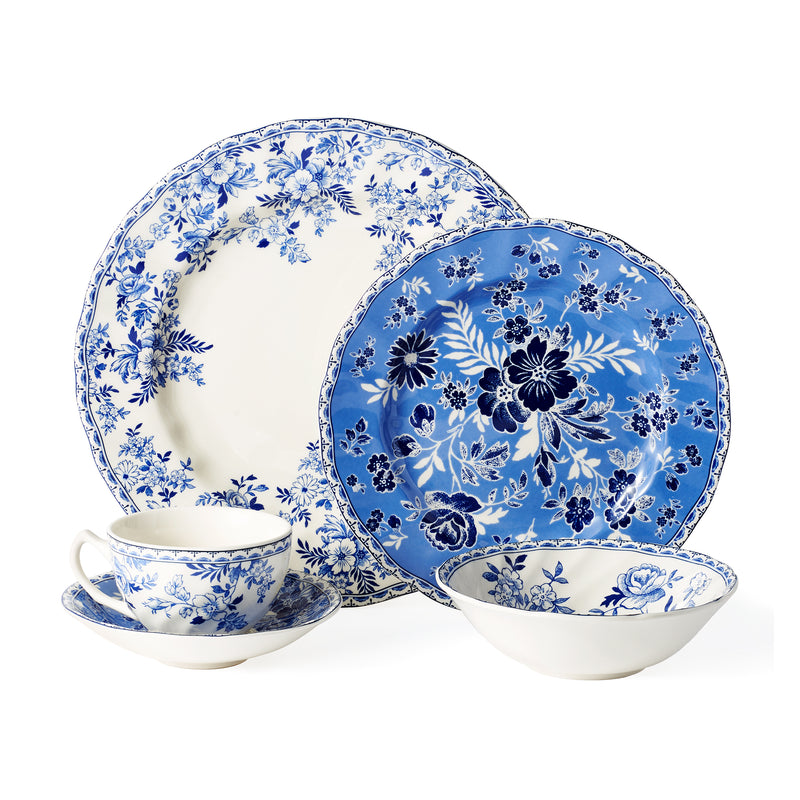 Blue floral earthenware dinnerware set with dinner plates, bowls, and teacup