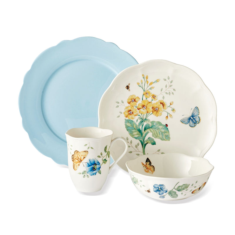 Porcelain dinnerware set with butterfly and floral meadow pattern, includes plates, bowls, and mug.