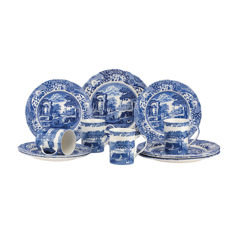 Ceramic dinnerware set with blue-and-white scenic plates, bowls, and cups