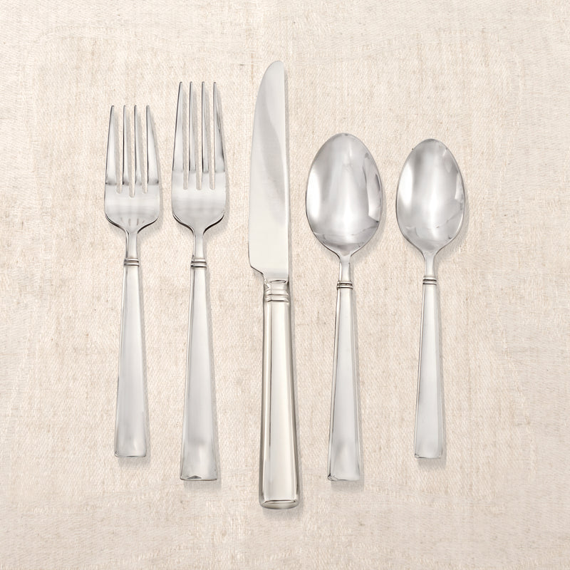Stainless steel flatware set with forks, knives, and spoons featuring Reed & Barton Perspective handles