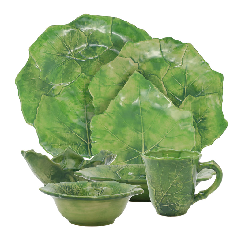 Leaf-shaped green ceramic dinnerware set: platter, bowls, and mug with leaf pattern.