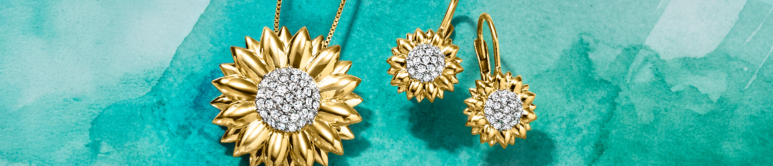 Gold sunflower pendant necklace and matching earrings with clear gemstone centers, displayed on a textured turquoise watercolor background.