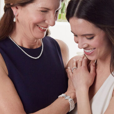 Your mom's moment. Major style for the mothers. Mom holding pocketbook wearing pearl bracelet.