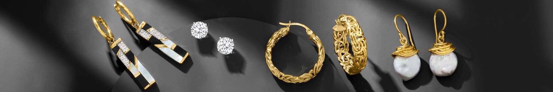 image featuring an assortment of earrings on a slate gray background