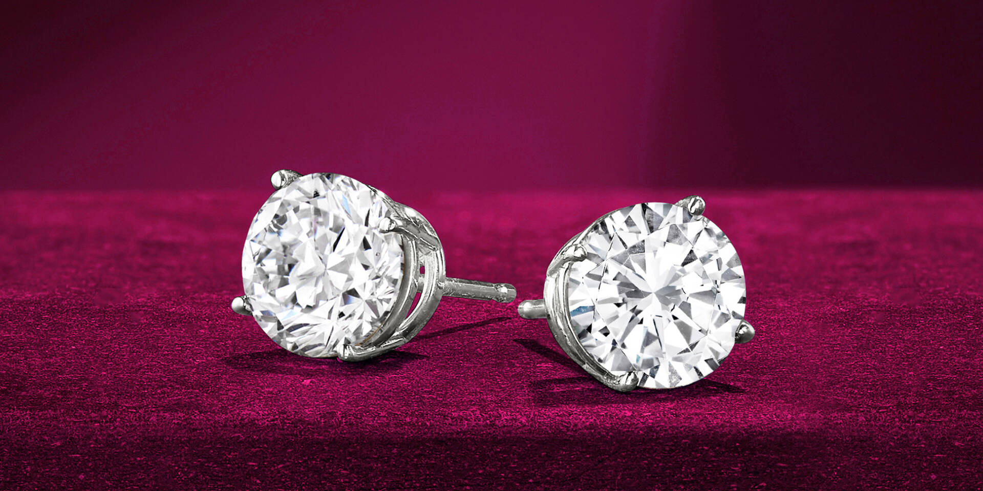 pair of diamond studs on red background