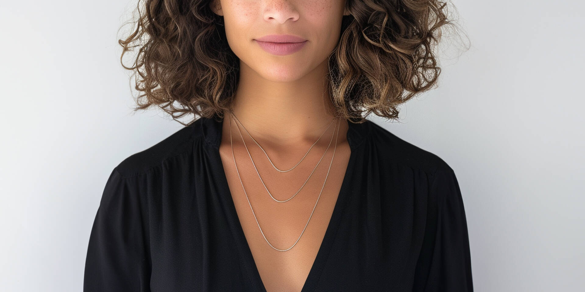 girl wearing three sizes of necklace