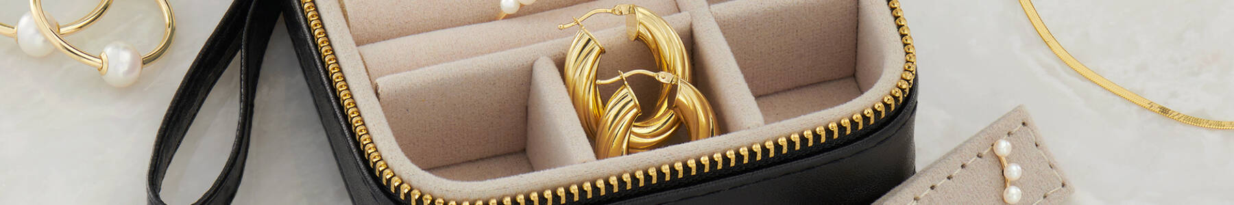 Home Vanity. Image featuring a jewelry box with a pair of gold hoop earrings