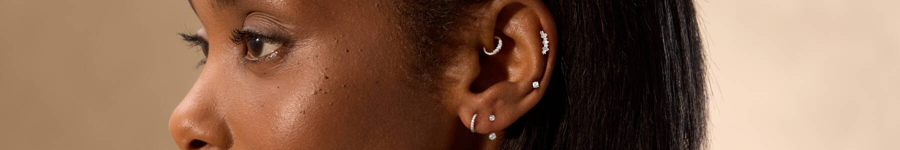 Image featuring a model wearing a large variety of earrings