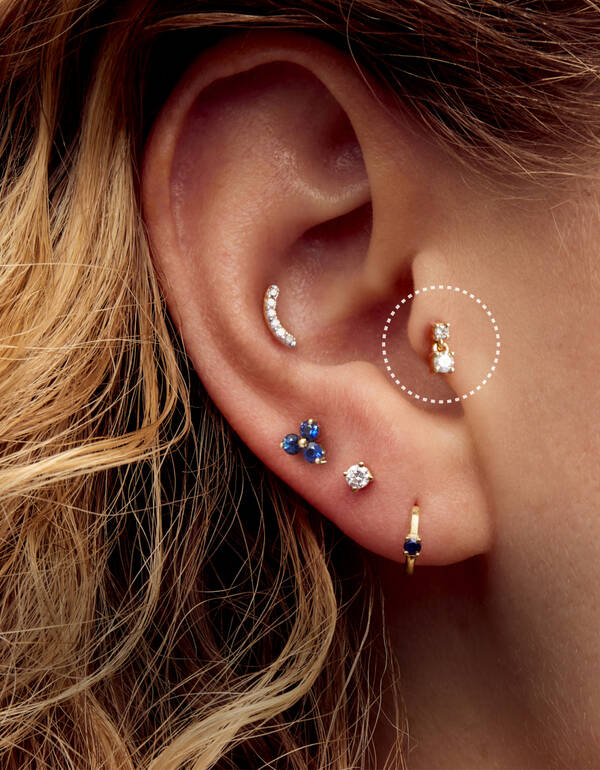 image featuring a model wearing a Tragus gold hoop earring